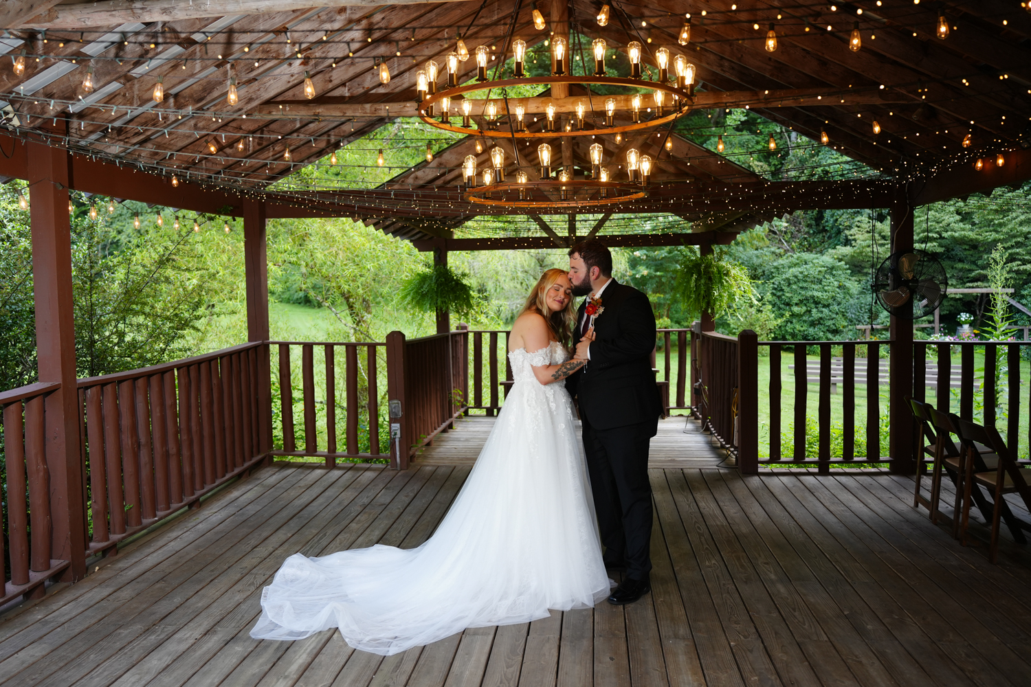 Couple enjoying a private moment beneath a circular chandelier in the creekside pavilion