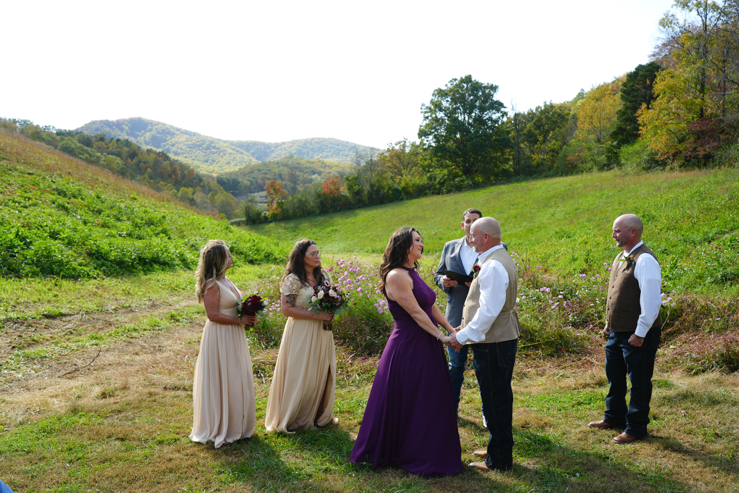 Couple exchanging vows during their wedding ceremony in a private mountain meadow at Honeysuckle Hills in Pigeon Forge