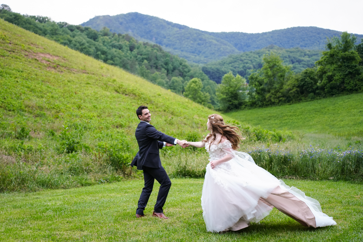 Wedding couple dancing joyfully in a mountain meadow at Honeysuckle Hills in the Smoky Mountains