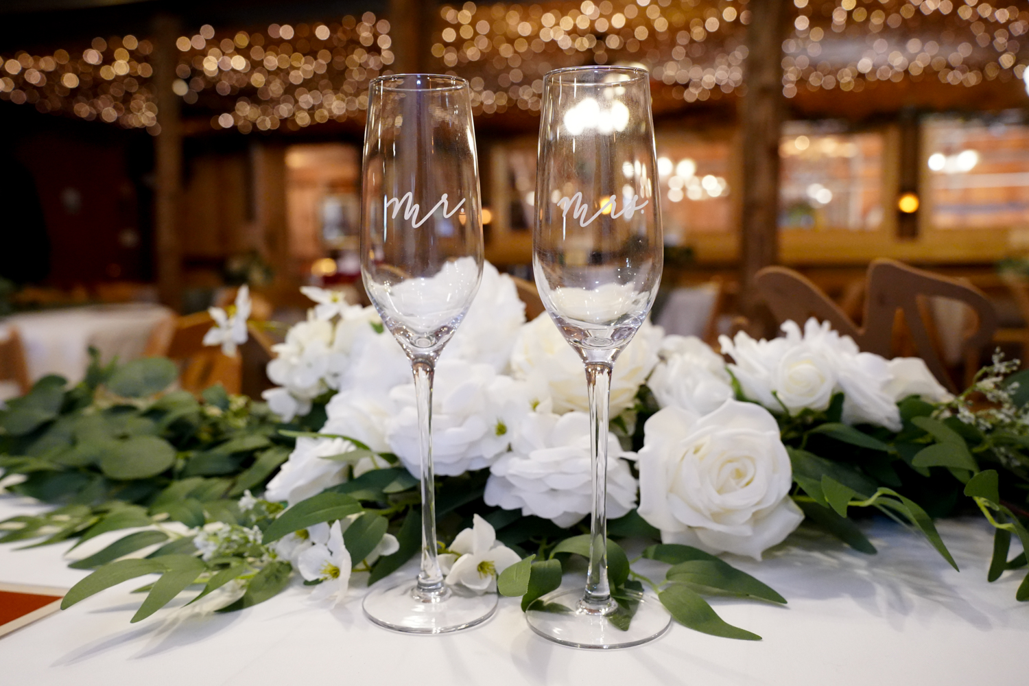 Toasting Glasses Romantic Reception-6002 Elegant toasting glasses in the reception space at Honeysuckle Hills with golden string lights