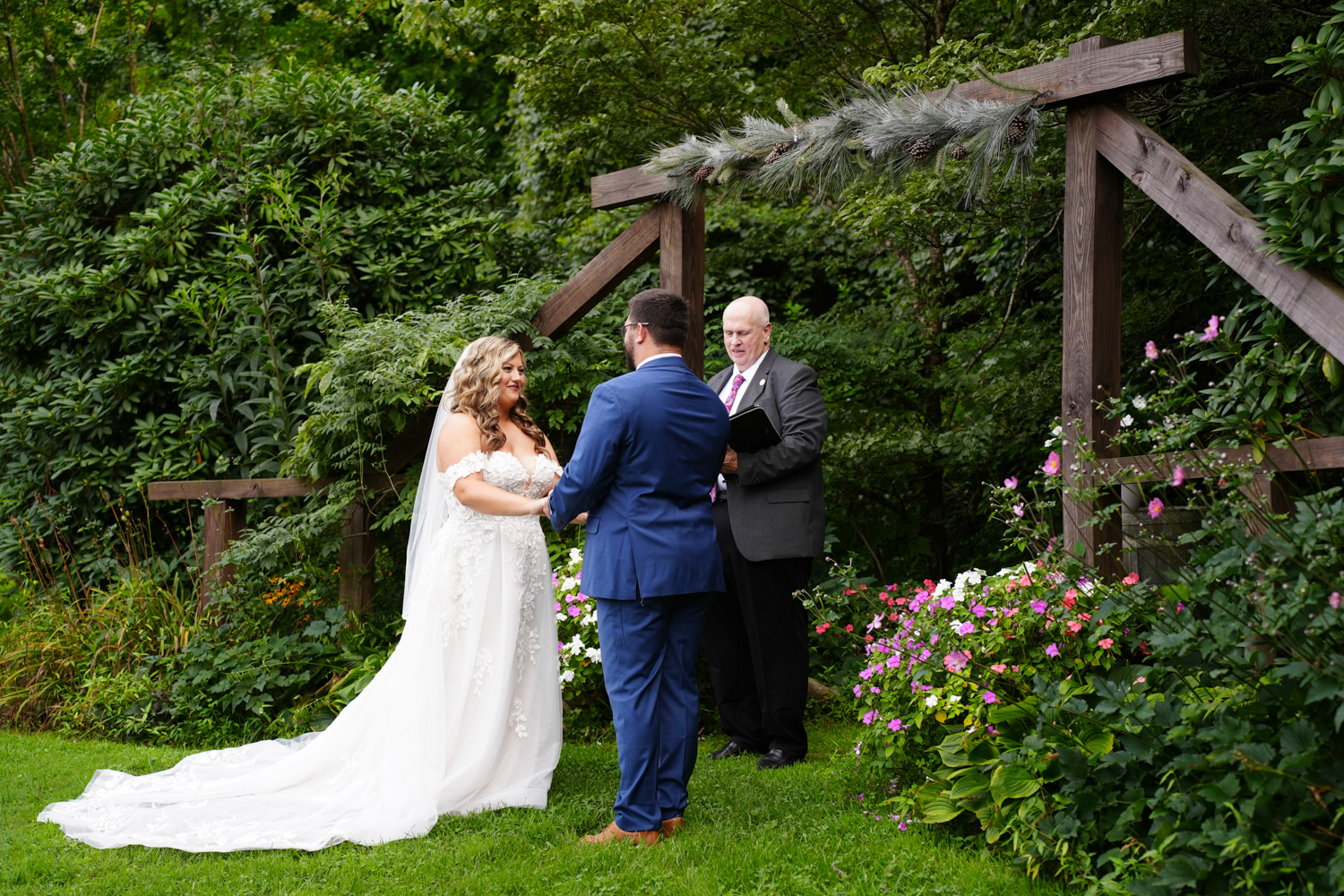 Forest themed wedding ceremony at a wooden arbor next to trees along a mountain ridge at Honeysuckle Hills in Pigeon Forge